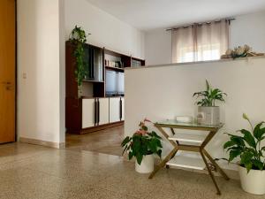 ein Wohnzimmer mit einem Tisch und Topfpflanzen in der Unterkunft Appartamento Alba in Riva del Garda
