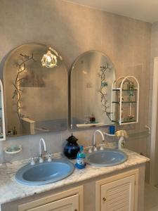 a bathroom with two sinks and two mirrors at B&B Portobello in Torrevecchia Teatina