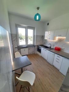 kuchnia ze stołem i krzesłami w pokoju w obiekcie Apartament Kaszownik w Toruniu