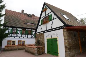 un edificio blanco y verde con una puerta verde en Apartment Grubenhaus20, en Freiberg