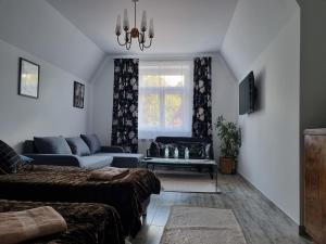 a living room with two beds and a couch at CZEKOLADA Apt. in Krynica Zdrój