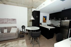 cocina y sala de estar con sofá y mesa en Condo "Imagine" - stationnement privé inclus en Quebec