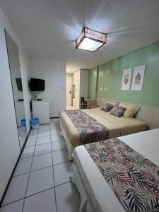 um quarto de hotel com três camas e uma televisão em Gran Lençois Flat Residence - Barrerinhas (Aptº Particular) em Barreirinhas