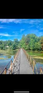 un pont sur une rivière avec des arbres en arrière-plan dans l'établissement Maison 2 Chambres - TV - CLIM - BABY FOOT, à Ruelle-sur-Touvre