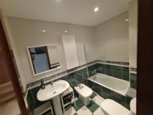 a bathroom with a sink and a toilet and a tub at Apartamento con vistas, amplio y luminoso in Monforte de Lemos