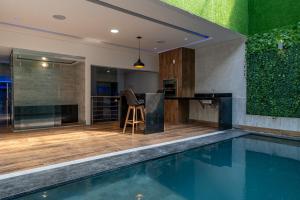 a house with a swimming pool and a kitchen at Drops Motel Manaus in Manaus