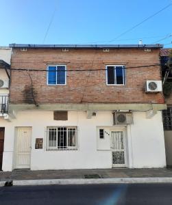 a brick building with barred windows and a street at del PARANA in Corrientes