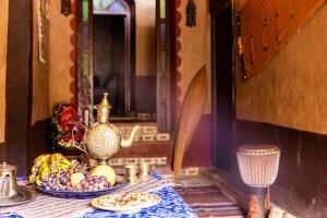 a table with a bowl of fruit and a vase at Dar Jamila in Achbarou