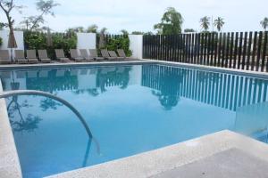 a swimming pool with chairs and a fence at Hacienda en Primavera, descanso Familiar total in Puerto Vallarta