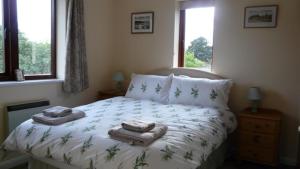 1 dormitorio con 1 cama con toallas en Bramley Cottage Holidays en Chichester