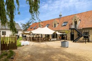 a large white tent in front of a building at B&B Leonie in Alveringem