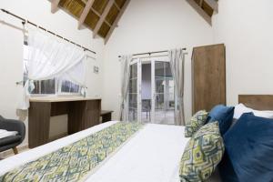 1 dormitorio con cama, escritorio y ventana en Laguna Vadu, en Vadu