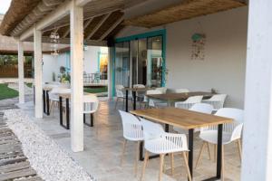 a patio with tables and white chairs and a table at Laguna Vadu in Vadu
