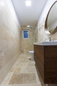 La salle de bains est pourvue d'un lavabo, de toilettes et d'un miroir. dans l'établissement Laguna Vadu, à Vadu