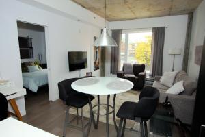 sala de estar con mesa blanca y sillas en Condo "Imagine" - stationnement privé inclus en Quebec