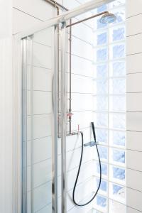 a shower with a hose in a bathroom with a window at MÔSS - Monastiraki Square Suite in Athens