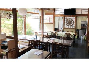 a dining room with tables and chairs and windows at Kagetsu Ryokan - Vacation STAY 04880v in Shizuoka +18 photos