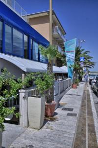 a sidewalk with potted plants in front of a building at Gabbiano Hotel in Civitanova Marche