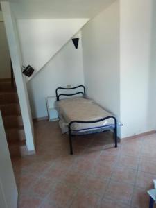 a small bed in a room with a staircase at La Terrazza nel carrùggio in Fezzano