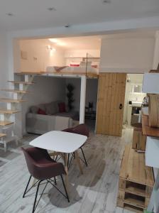 uma sala de estar com uma mesa e cadeiras num quarto em 7 Trevos Houses A em Santiago do Cacém