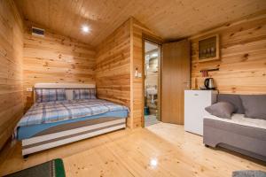 ein kleines Zimmer mit einem Bett und einem Sofa darin in der Unterkunft Sunny in Nikšić