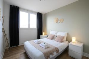 Un dormitorio con una cama blanca con dos luces. en expat renting - Le Bohème Nature - Proche Airbus, en Colomiers