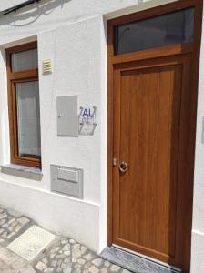 een houten deur aan de zijkant van een gebouw bij 7 Trevos Houses A in Santiago do Cacém