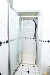 La salle de bains est pourvue d'une douche avec une porte en verre. dans l'établissement Ultimate Comfort 4-Bedroom Property for 7 People, à Bromley