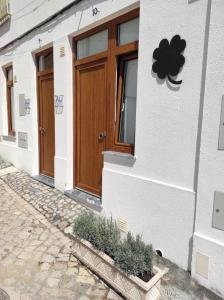 ein weißes Gebäude mit einer Holztür darauf in der Unterkunft 7 Trevos Houses B in Santiago do Cacém