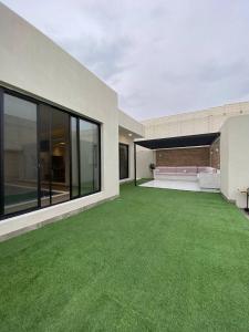 ein leerer Hof mit grünem Gras in einem Haus in der Unterkunft شاليهات ضوء in Ta'if