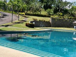 - une piscine d'eau bleue dans la cour dans l'établissement Jaco Carara Nativa Garden Suite ELEGANTE&EXCLISIVO, à Puntarenas