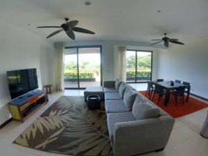- un salon avec un canapé, une télévision et une table dans l'établissement Jaco Carara Nativa Garden Suite ELEGANTE&EXCLISIVO, à Puntarenas