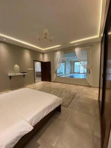a bedroom with a large bed and a large window at شاليهات ضوء in Taif