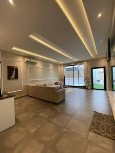 uma grande sala de estar com um sofá e janelas grandes em شاليهات ضوء em Taif