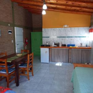 uma cozinha com uma mesa de madeira e uma cozinha com um frigorífico em Mainame Traslasierra em Los Hornillos