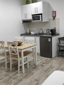 cocina con mesa, sillas y microondas en 7 Trevos Houses B, en Santiago do Cacém