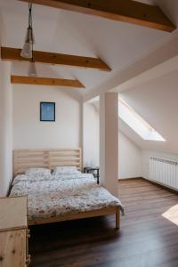 1 dormitorio con 1 cama y suelo de madera en Dom Wypoczynkowy - Alexander, en Cisiec