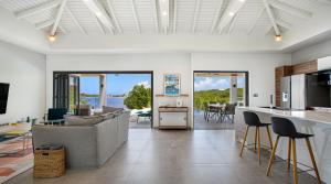 a living room with a couch and a table with chairs at Enjoy Villa - Completely NEW! in Baie Longue
