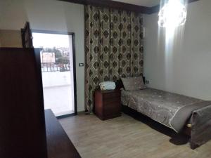1 dormitorio con 1 cama y puerta corredera de cristal en City Center Furnished Apartment en Madaba