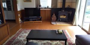 a living room with a table and a fireplace at Minami Aso Guest House Hana hana - Vacation STAY 13316 in Takamori