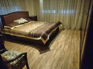 a bedroom with a bed and a wooden floor at City Center Furnished Apartment in Madaba