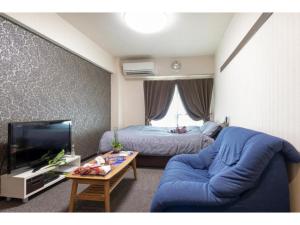 a living room with a blue couch and a bed at cozy house - Vacation STAY 13159 in Kyoto