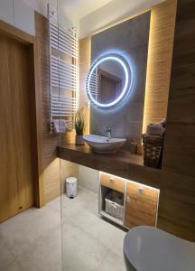 La salle de bains est pourvue d'un lavabo et d'un miroir. dans l'établissement Malta Delux Apartment, free parking, self check-in 24h, à Poznań