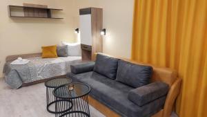 a living room with a couch and a bed at Sunrise City A2, Sarafovo in Burgas