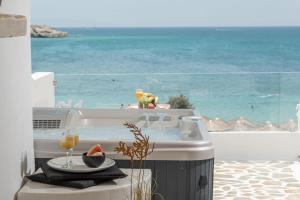 a hot tub with a plate of watermelon and wine glasses at Hotel Fanis in Agia Anna Naxos