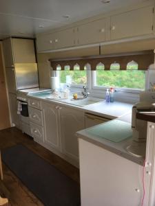 a kitchen with white cabinets and a sink and a window at Bazanmoes Shed No: 49 in Aberystwyth