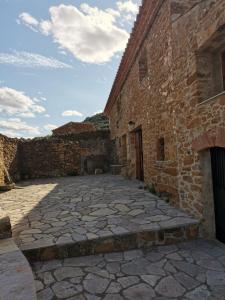 un patio de un antiguo edificio de piedra con un cielo en Masia Campos Culla, en Culla