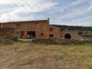a stone house with people sitting outside of it at Masia Campos Culla in Culla