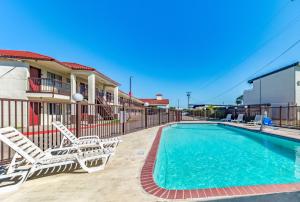 a swimming pool with two lounge chairs and a swimming pool at Red Roof Inn Dallas - Mesquite Fair Park NE in Mesquite