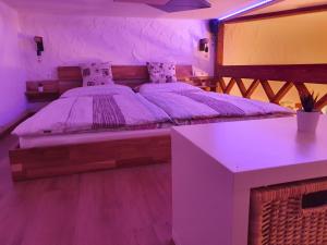 Un dormitorio con una cama con una mesa y luces violetas en Studio Srce, en Kranjska Gora